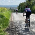 Long shot of three cyclists on road