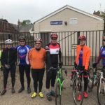 Group of club cyclists standing outside club house